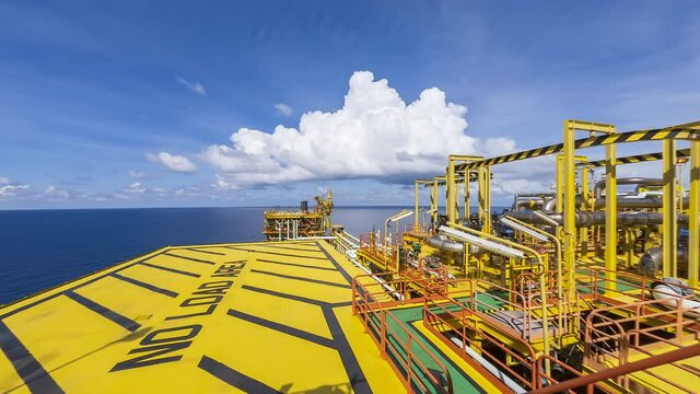 Oil and gas industry at offshore. 4K time lapse scene at oil and gas platform complex with dramatic clouds movement and blue sky. 