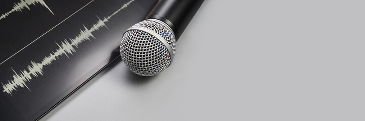 Podcast record. Microphone and sound track at tablet. Grey monochrome. Audiobook and podcasting....