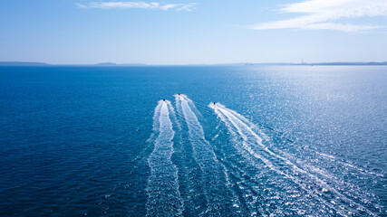 沖に向かうジェットスキーの白波が映える空撮写真