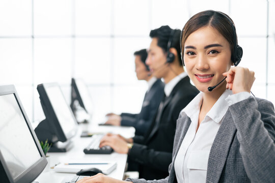 Asian Team Call Center, Customer Service, Telesales In Casual With Headset Or Headphone And Look At Camera