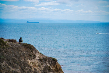 Fototapeta na wymiar Hombre pensando en acantilado viendo al mar
