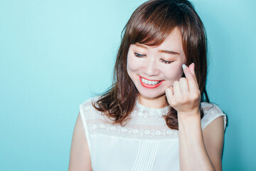 指ハートをする女性
