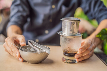 Caucasian man and traditional drip brewed Vietnamese coffee from a phin filter
