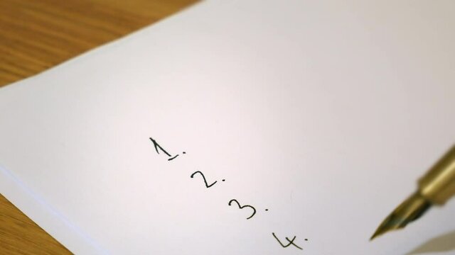 Numbers are written in a list on a blank sheet of paper with a fountain pen in ink.