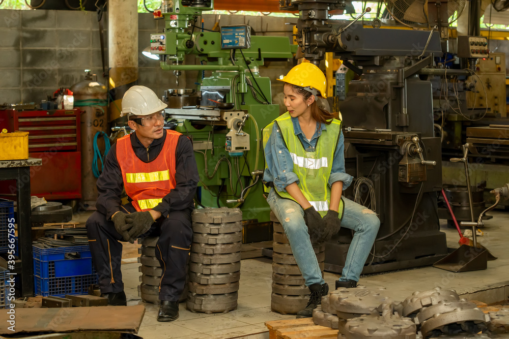 Poster industrial engineer discusses with factory worker at factory.
