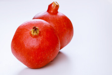 Whole red pomegranate isolated on white background.