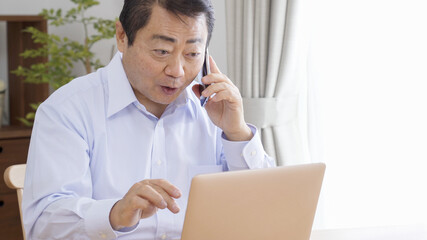 家でテレワークする中高年のビジネスマン