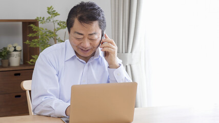 家でテレワークする中高年のビジネスマン