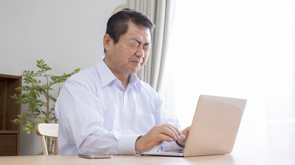 家でテレワークする中高年のビジネスマン