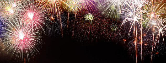 Fireworks happy new year Many colorful colors stacked on a black background In the middle there is a space for writing messages.