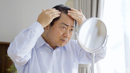 身だしなみを整える中高年男性