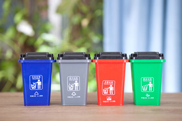 Different color classification trash bin models are arranged in a row