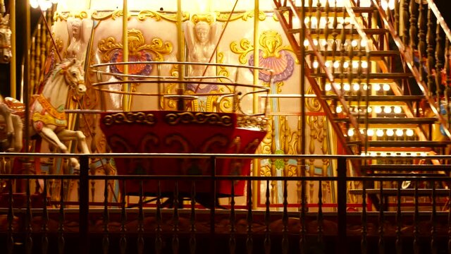 Carousel roundabout or merry-go-round with colourful horses and retro vintage wooden seat