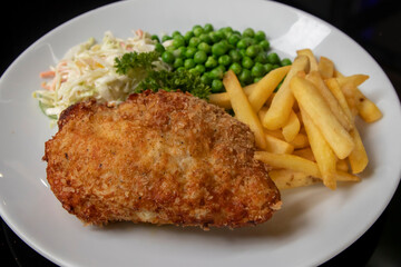 Chicken Kiew with French fries, peas and coleslaw