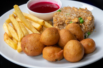 Chicken balls with fried rice, French fries and sweet & sour sauce