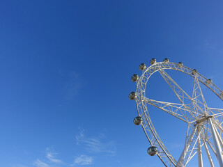 Ferris wheel against blue sunny sky