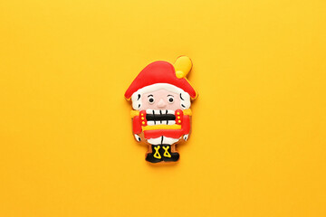 Nutcracker ginger biscuit on a yellow background. New year and Christmas background. Flat lay