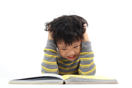 Little Asian Boy Frustrated Over Homework With His Both Hand On His Head. Boy Studying At Table Isolated On White Background.