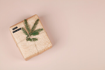 Christmas eco gift box with text and tree branch on beige background.