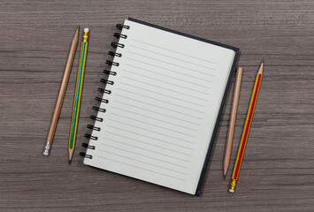 Top view close up notebook with pencil on wood table