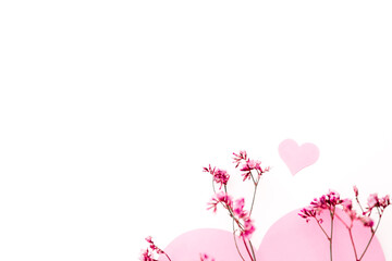 A large pink heart with a place for text decorated with small pink flowers on a white background