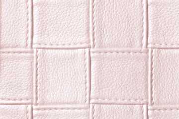 Fototapeta premium Texture of light pink leather background with square pattern and stitch, macro.