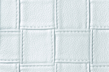 Texture of light blue leather background with square pattern and stitch, macro.