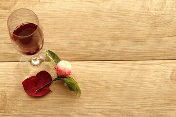 白いテーブルに赤い葉とピンクの花と赤ワイン