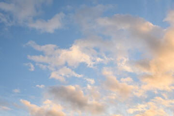 Colorful blue sky and clouds highlighted by setting sun, as a nature background
