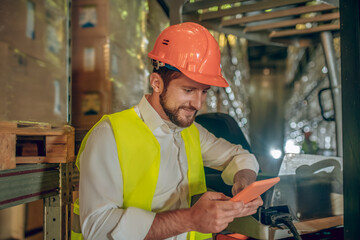 Young bearded worker watching something on the tablet