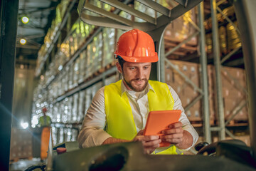 Young bearded worker watching something on the tablet and looking concentrated