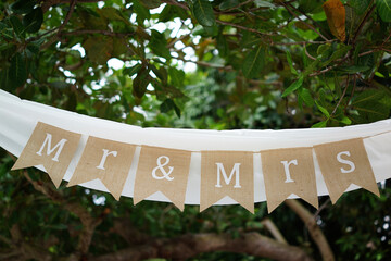 Mr and Mrs brown wedding garland sign on string under arch