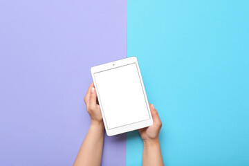 Woman holding tablet computer on color background