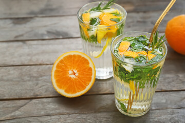 Glasses of citrus mojito on wooden table