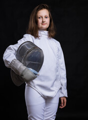 Teenage girl fencer dressed in uniform with epee and helmet