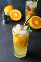 Glass of orange mojito on gray background