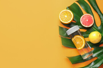 Bottle of clean water with citrus on color background