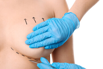 Woman and doctor with lancet on white background, closeup. Concept of breast augmentation