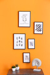 Table near wall with beautiful pictures