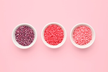 Obraz na płótnie Canvas Bowls with sweet sprinkles on color background