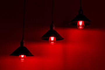 Three lamps with vintage incandescent bulbs. Red light.