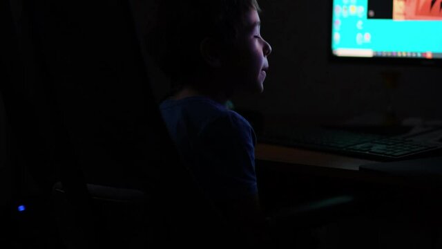 Asian boy late at night launches the game on the computer, typing something interesting surfing Internet, moonlight shines from window. close up view. Slow motion nvideo. stock footage