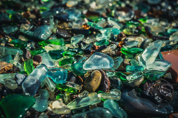 Natural background with sea glass close-up on sand.
