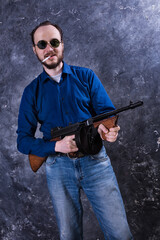 Mature man in sunglasses with tommy gun