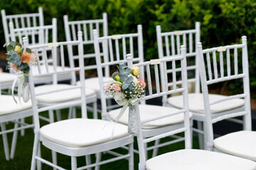 Fototapeta na wymiar Outdoor wedding venue chairs with flower and ribbon decoration
