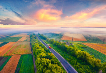 Wonderful dawn on Ukrainian countryside with foggy fields. Marvelous summer sunrise on outskirts of...