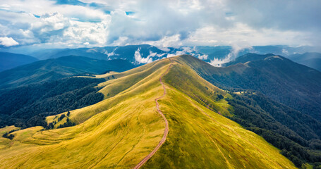 Aerial landscape photography. Dramatic morning view from flying drone of Svydovets mountain range with old country road. Misty outdoor scene of Carpathian mountains, Ukraine, Europe. © Andrew Mayovskyy