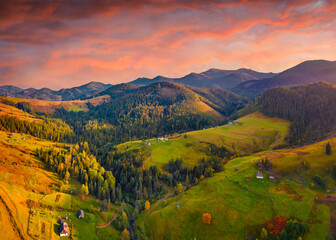 Unbelievable autumn view from flying drone of Dzembronya village. Aerial landscape photography. Picturesque evening scene of Carpathian mountains, Ukraine, Europe.