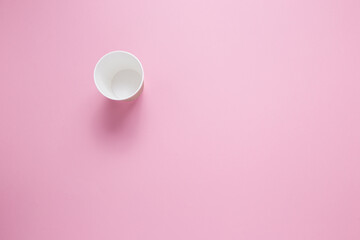 Paper cup for hot coffee or tea on a pink isolated background.