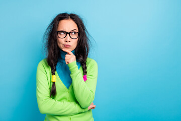 Photo of minded serious focused young schoolgirl hold hand chin look empty space isolated on blue color background